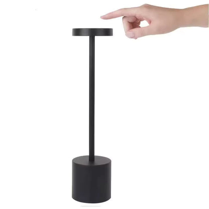 Black cordless table lamp with modern round metal design. Rechargeable table lamp centered on a clean white background