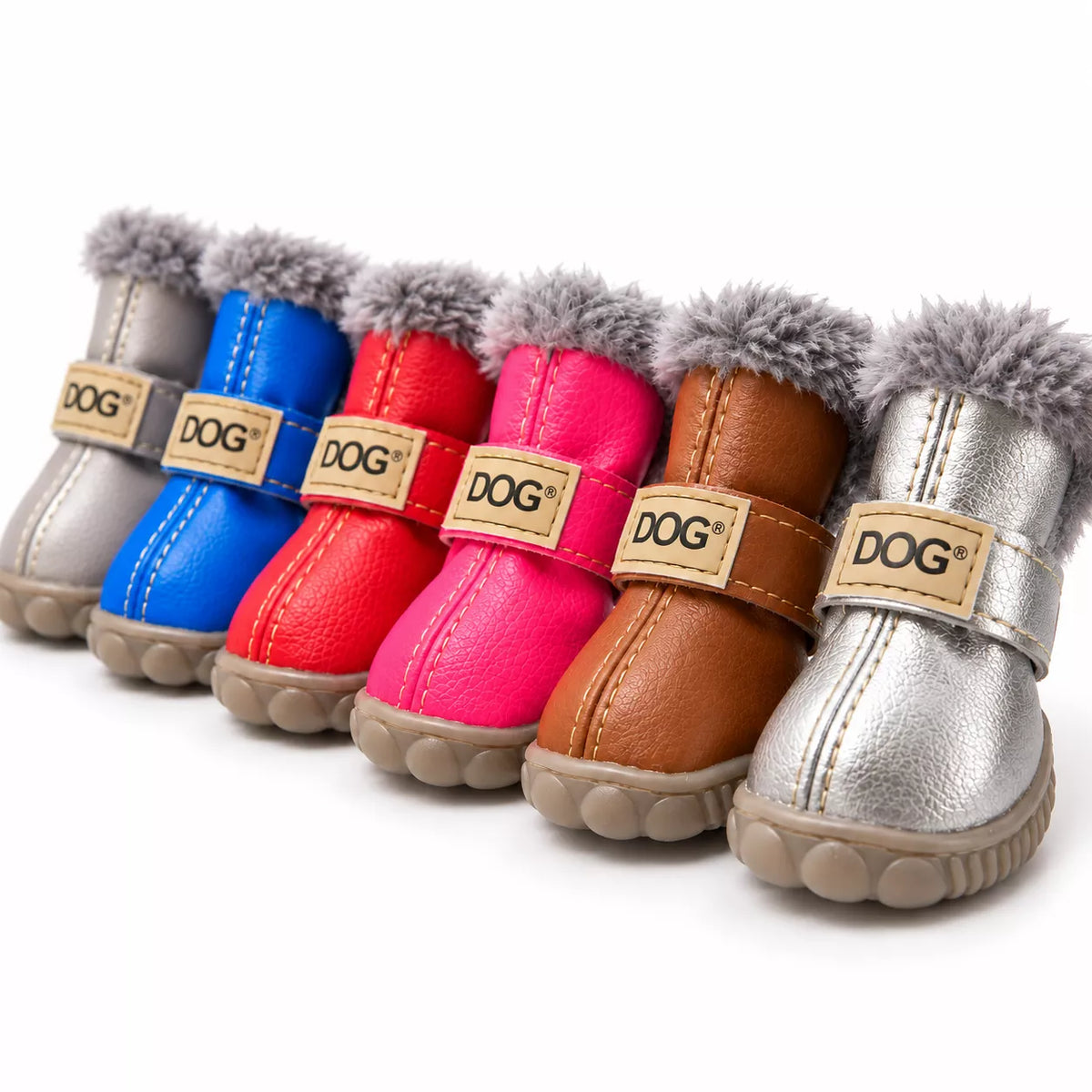 Six small dog boots in different colors lined up on a white background. The boots have faux-leather uppers in silver, blue, red, pink, brown, and metallic silver, with gray faux-fur trim and a tan strap featuring a 'DOG' brand patch.